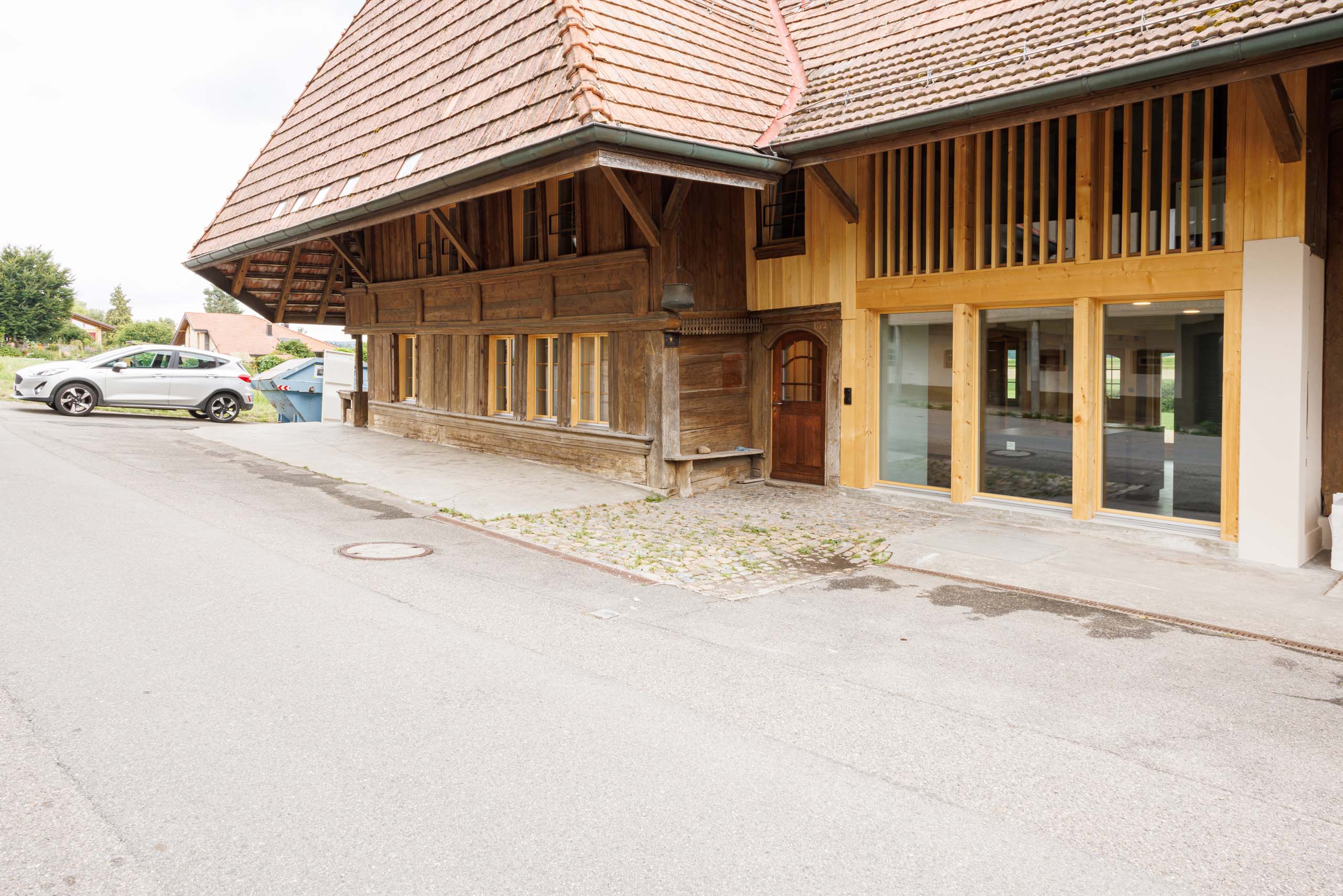 Rustikales Bauernhaus welches von der Kobi Architektur AG in Biezwil (Region Buechibärg) umgebaut wurde. Der modernisierte Bauernhof ist nun mit einem neuen modernen Eingangsbereich ausgestattet mit einer grossen Fensterfront und aus hellem Holz